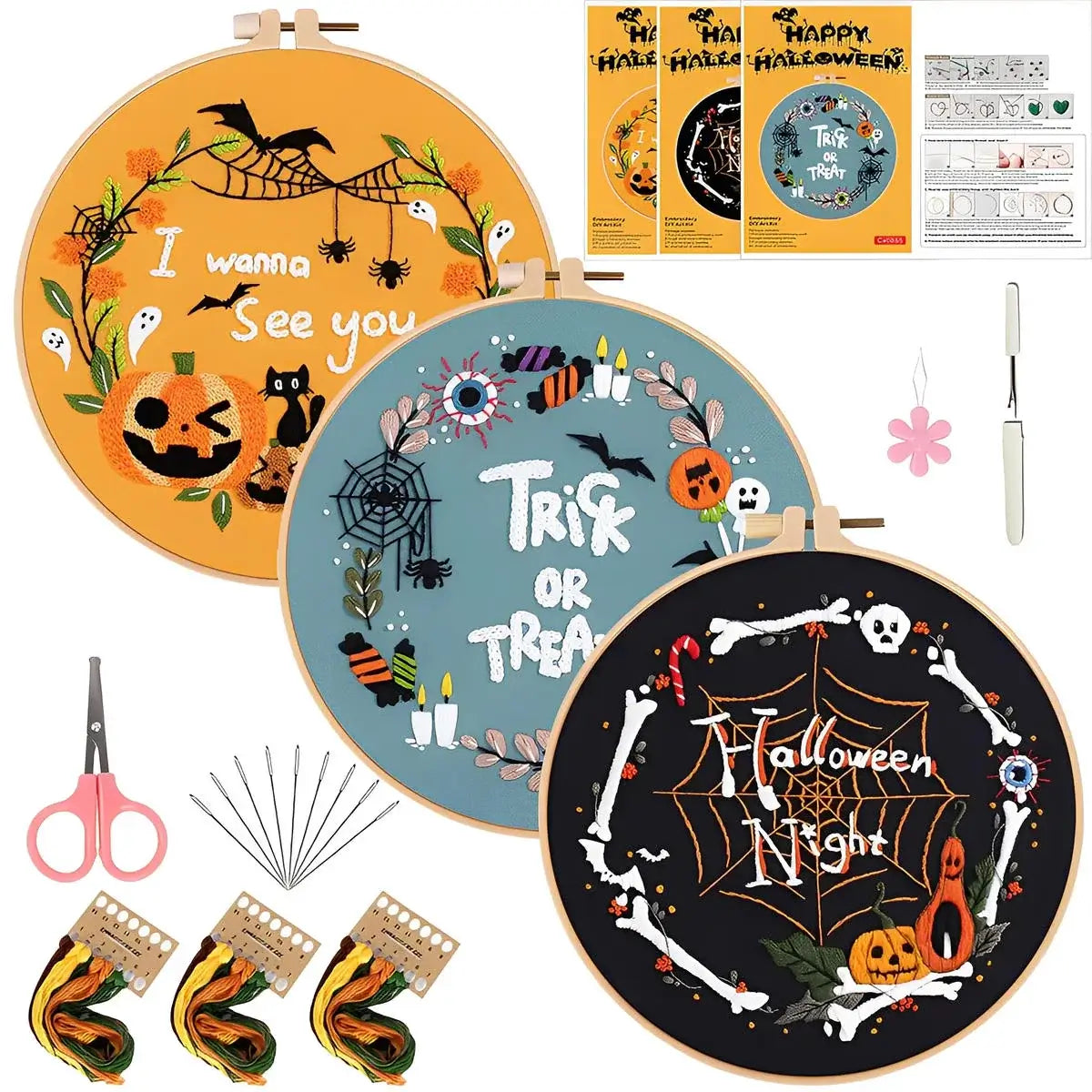 Halloween-themed embroidery hoops with supplies on a white background