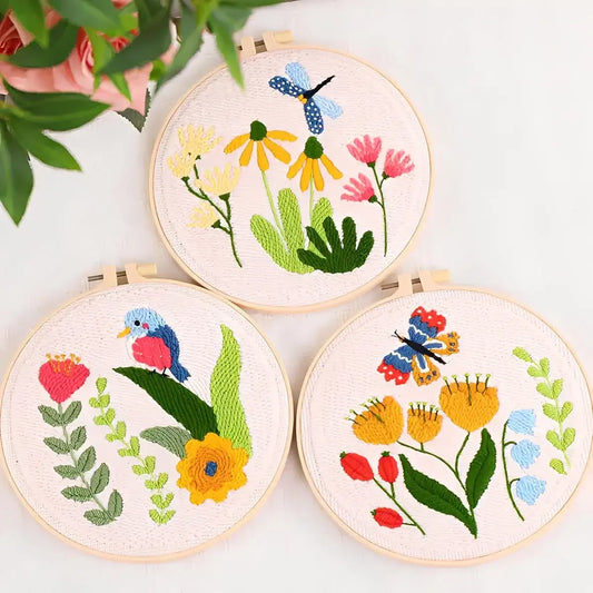 CraftHoop Songbird & Blossoms Punch Needle Kit displayed with vibrant floral and wildlife designs in embroidery hoops.