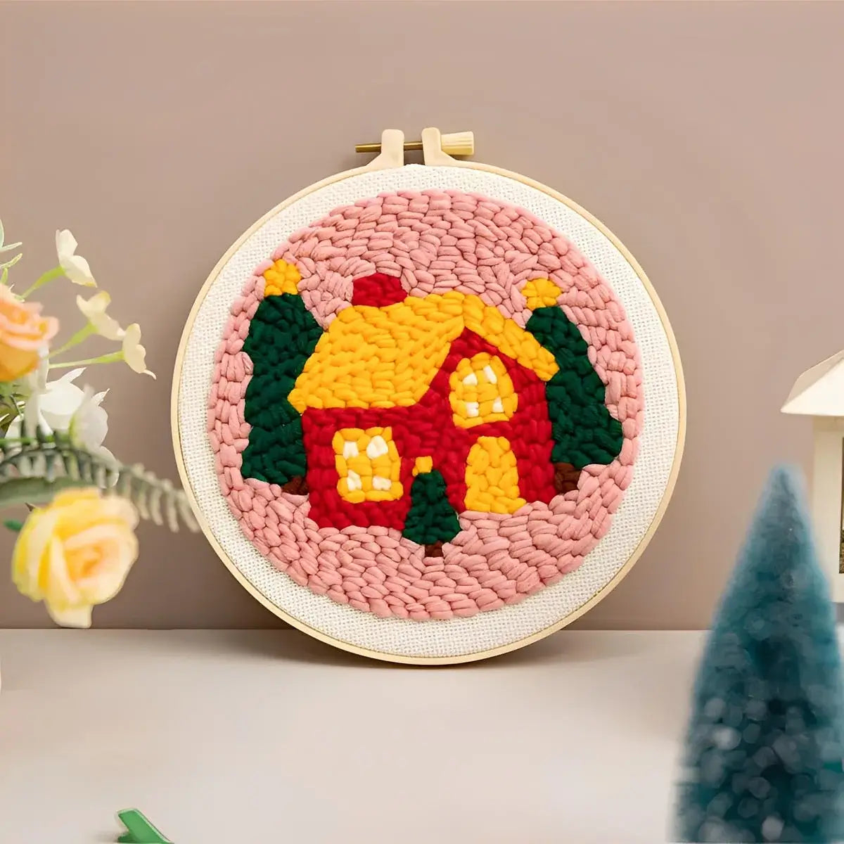 CraftHoop Christmas Cheer Punch Needle Kit finished project featuring a colorful house with trees, perfect for holiday decor.