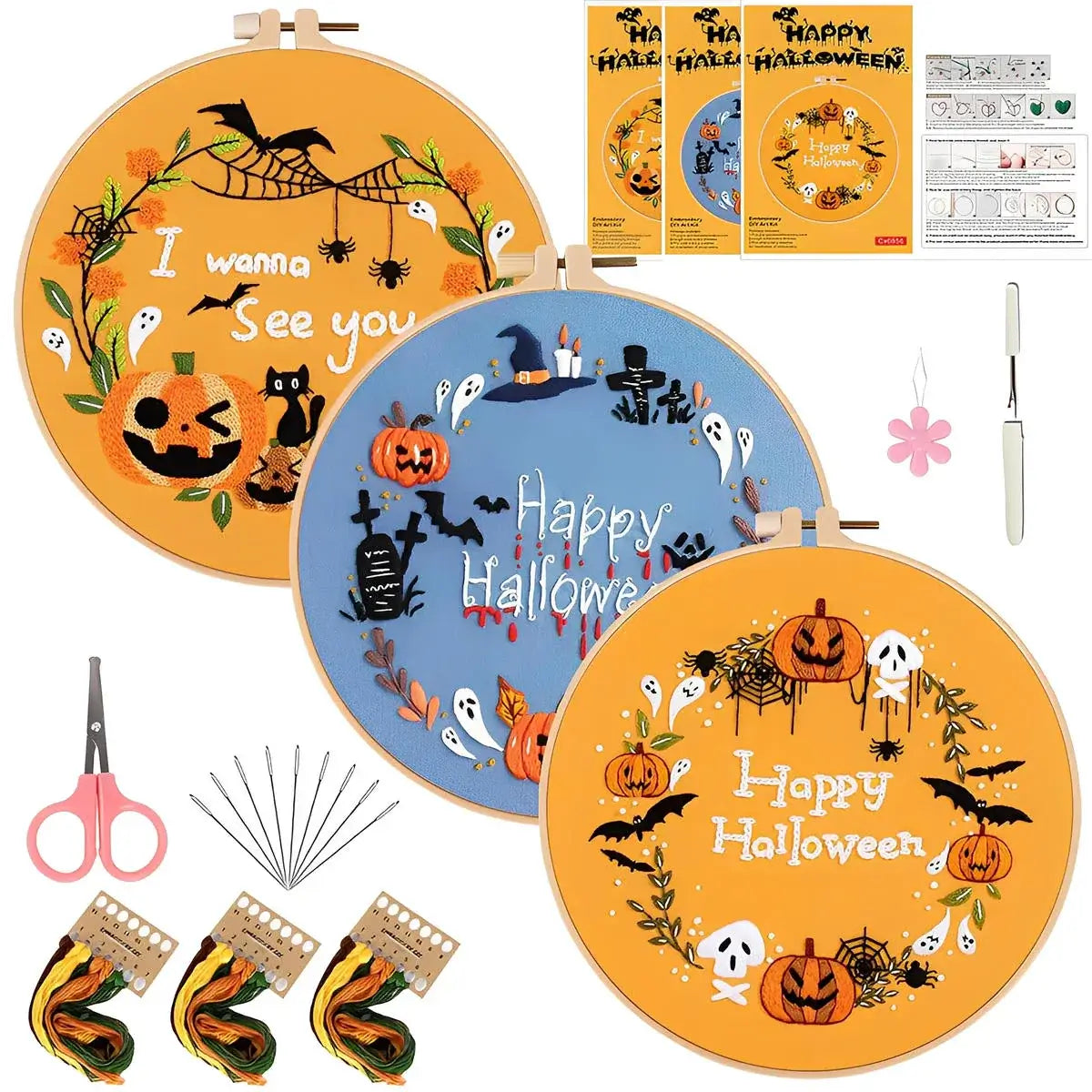 Halloween-themed embroidery hoops with supplies on a white background