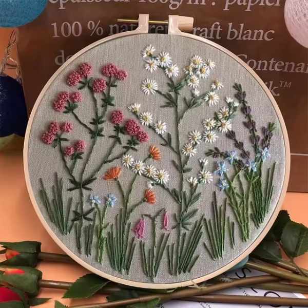 CraftHoop embroidery kit featuring a detailed design of red flowers and green leaves on fabric, displayed on a wooden hoop.