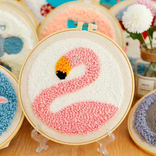 CraftHoop punch needle embroidery kit with a pink flamingo design, displayed on a light background with yarn and embroidery tools.