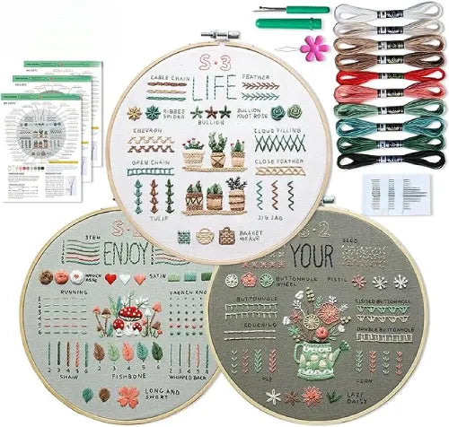 Complete beginner embroidery kit by CraftHoop with 3 pre-printed pattern fabrics, bamboo embroidery hoop, colored threads, and instructions, showcasing the included materials