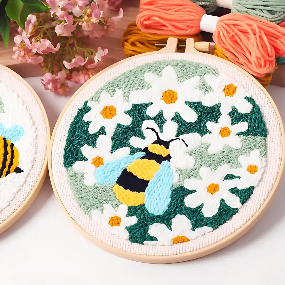CraftHoop Buzz & Bloom Punch Needle Kit featuring playful bees and blooming daisies on a stitched hoop.