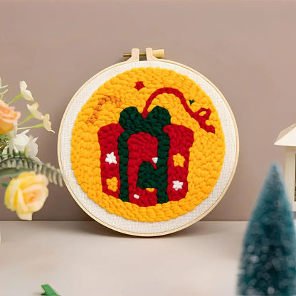 CraftHoop Christmas Cheer Punch Needle Kit festive punch needle artwork featuring a colorful gift design.