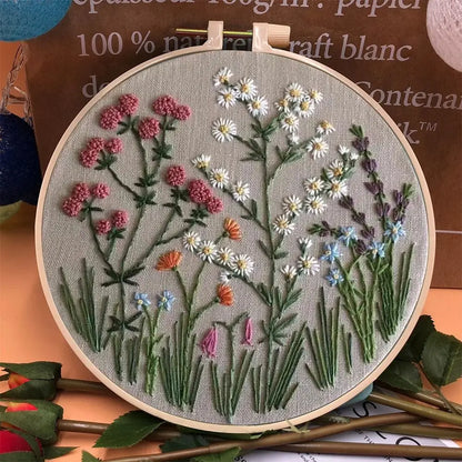 CraftHoop embroidery kit with a detailed design of red flowers and green leaves, displayed on a wooden hoop.