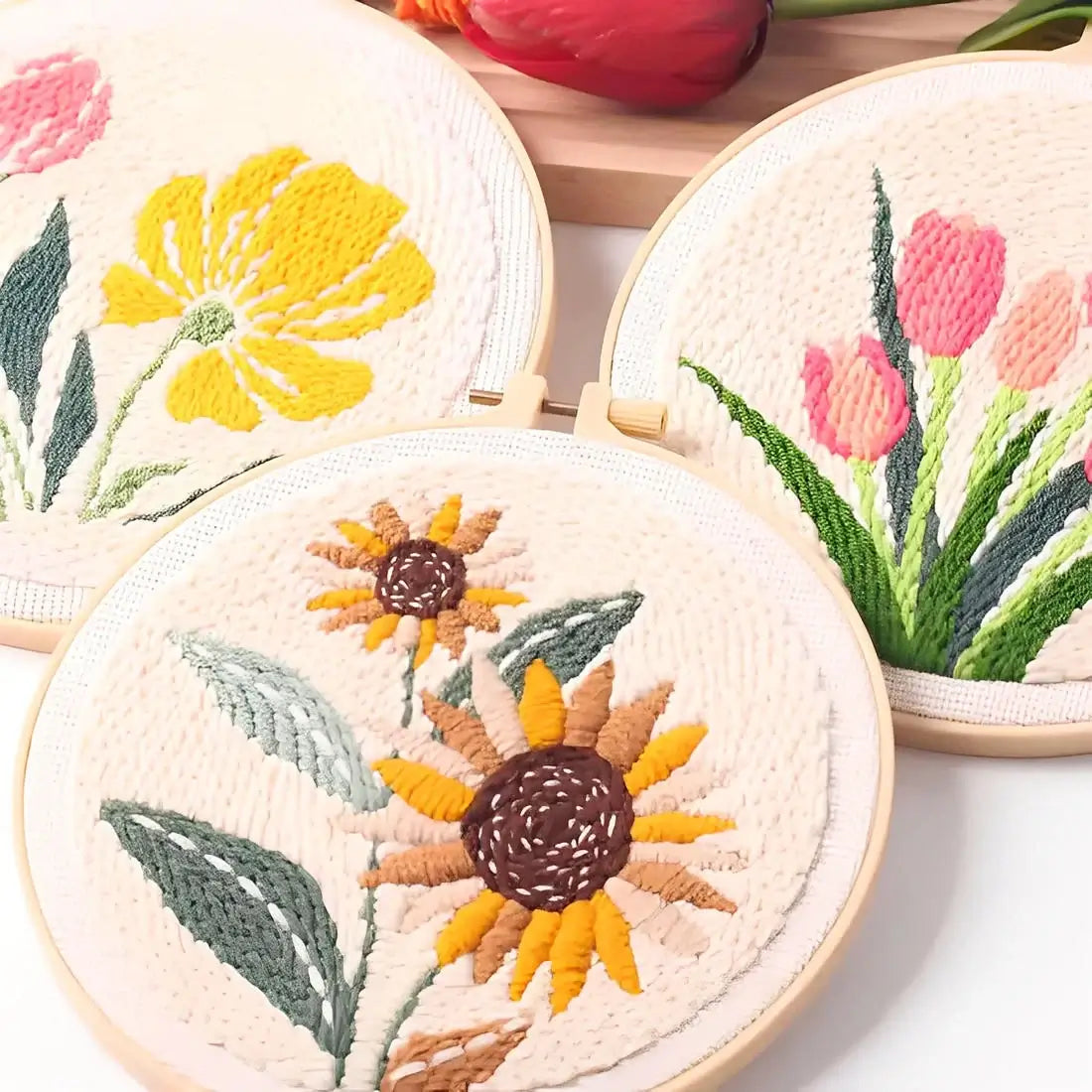 CraftHoop Garden Joy Punch Needle Kit featuring vibrant floral designs with tulips, poppies, and sunflowers in embroidery hoops.