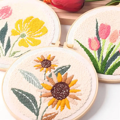 CraftHoop Garden Joy Punch Needle Kit featuring vibrant floral designs with tulips, poppies, and sunflowers in embroidery hoops.