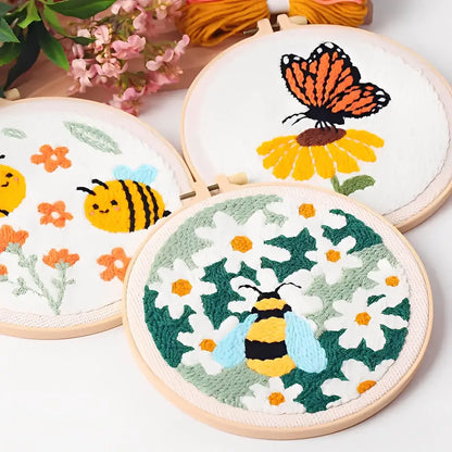 CraftHoop Buzz & Bloom Punch Needle Kit showcasing colorful designs of bees, butterflies, and daisies in embroidery hoops.