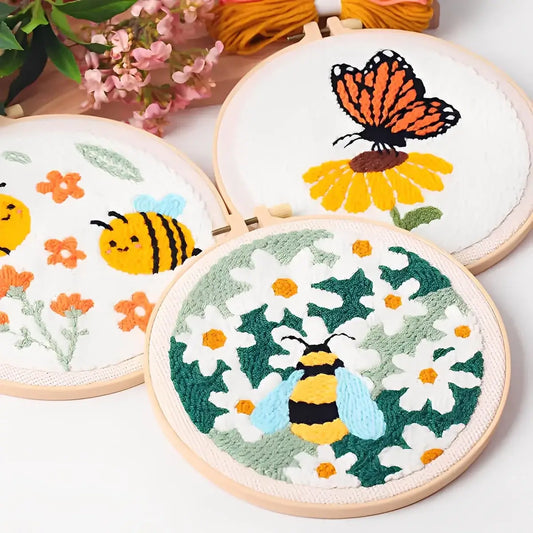CraftHoop Buzz & Bloom Punch Needle Kit showcasing colorful designs of bees, butterflies, and daisies in embroidery hoops.