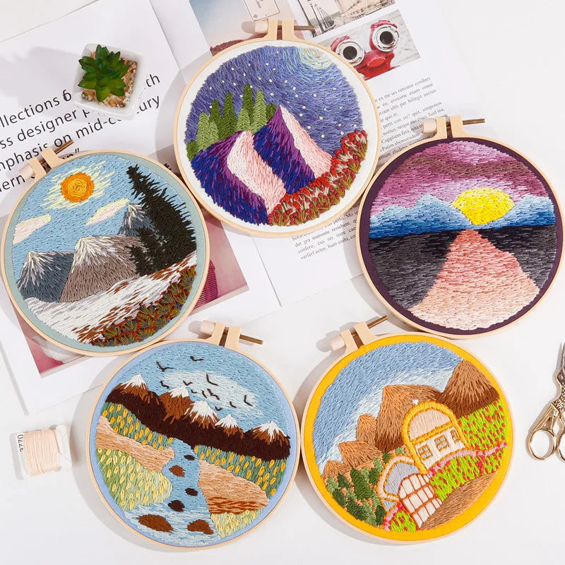 Collection of landscape-themed embroidery kits from CraftHoop, showcasing various colorful designs including mountains, fields, and sunsets, arranged in a circular pattern