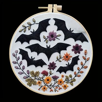 CraftHoop Crow Magic Halloween Embroidery Kit featuring black bats and floral designs in an embroidery hoop.