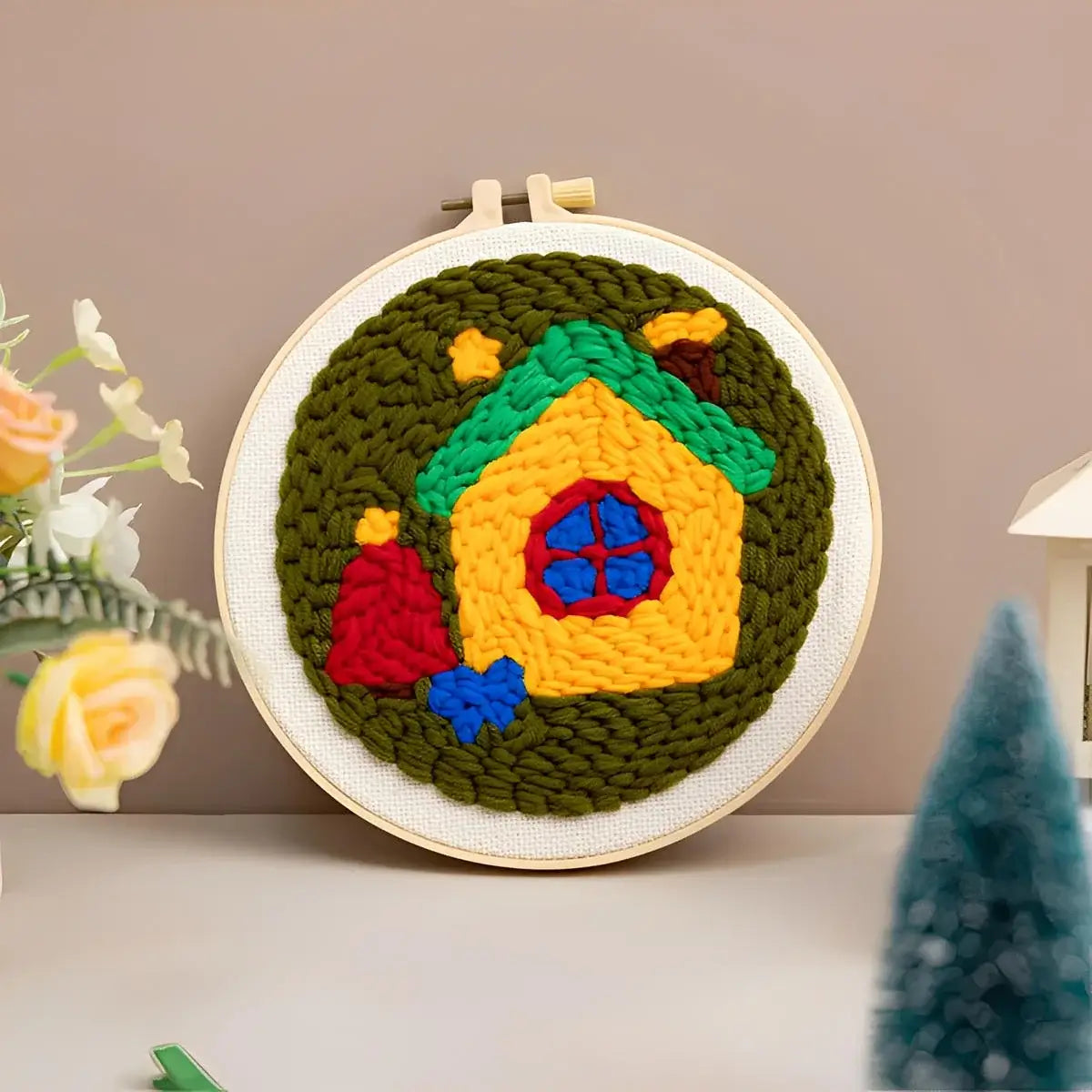 CraftHoop Christmas Cheer Punch Needle Kit featuring a colorful punch needle design of a cozy holiday house.