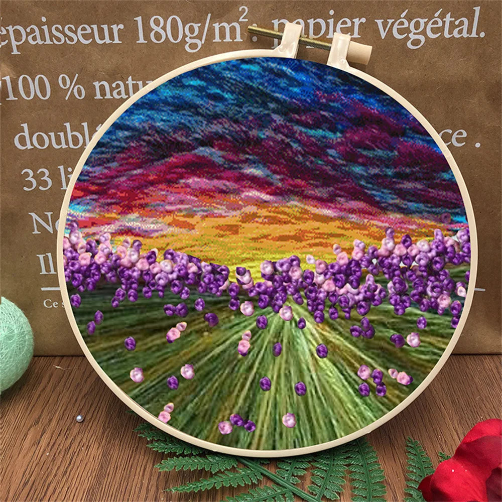 CraftHoop landscape embroidery kit showcasing a mountain sunset design with a colorful sky, displayed on a wooden surface with decorative leaves