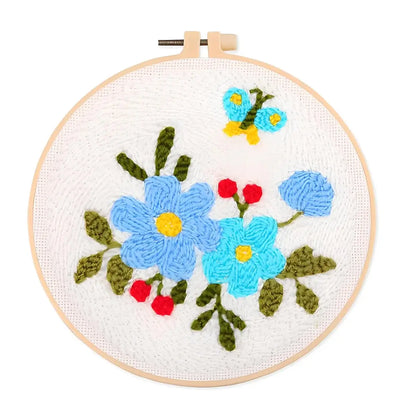 CraftHoop Garden Glow Punch Needle Kit floral design featuring cheerful blue flowers and a butterfly.