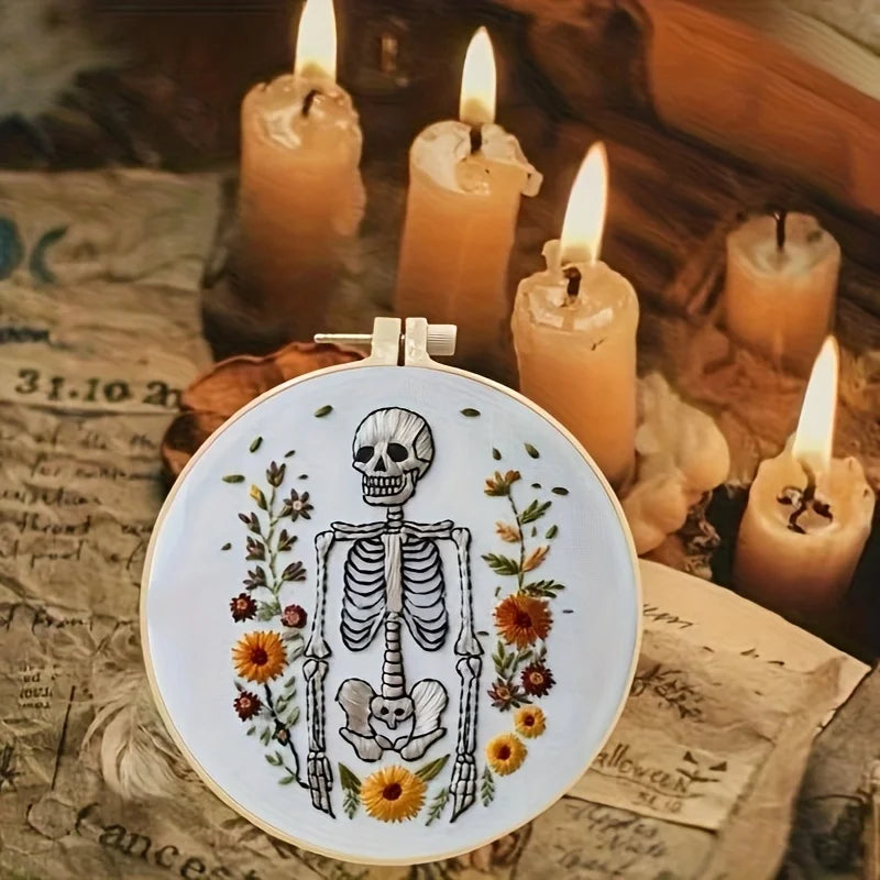CraftHoop Crow Magic Halloween Embroidery Kit displayed with candles and vintage papers.