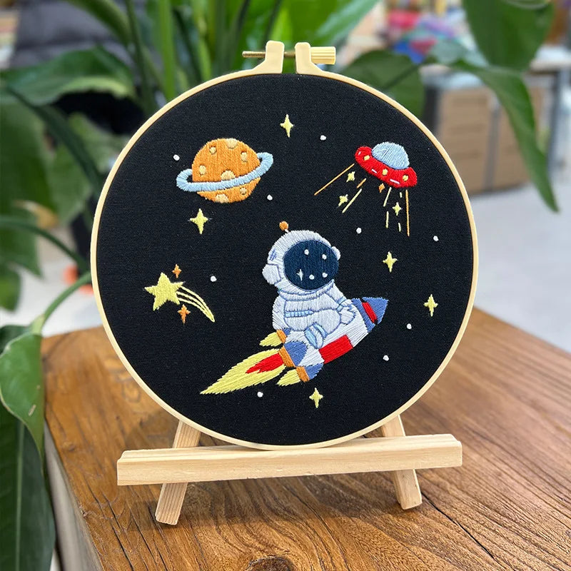 CraftHoop Little Astronaut Embroidery Kit showing intricate details of space design including stars and moon on a dark fabric.