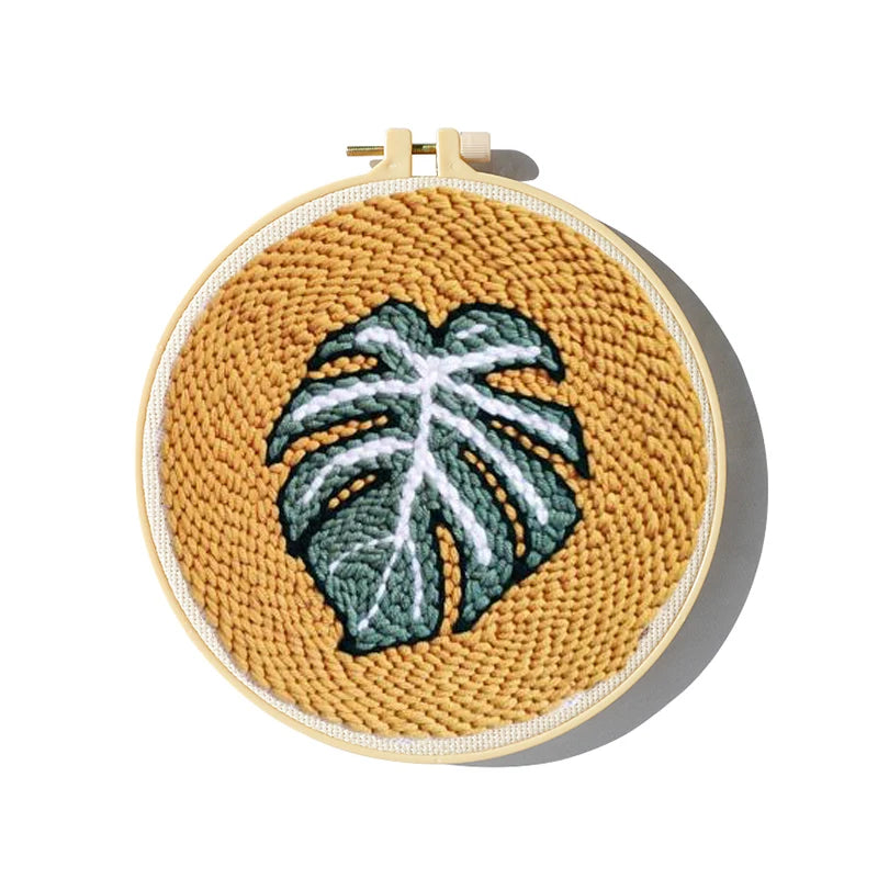 CraftHoop punch needle embroidery kit featuring a completed leaf design with vibrant colors, displayed on a wooden hoop.