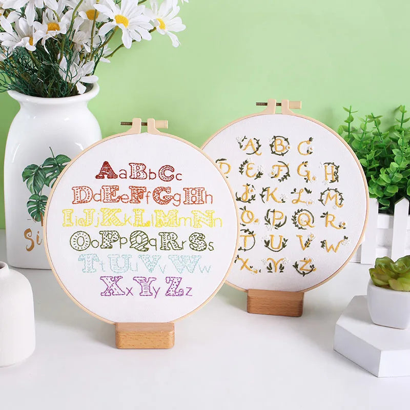 Close-up view of CraftHoop Beginner's Alphabet Embroidery Kit showcasing embroidered letters in floral patterns.