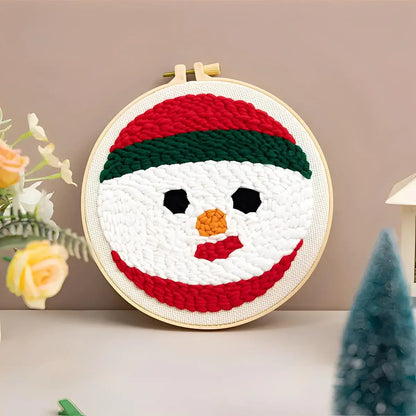 CraftHoop Christmas Cheer Punch Needle Kit snowman design in an embroidery hoop with festive colors.