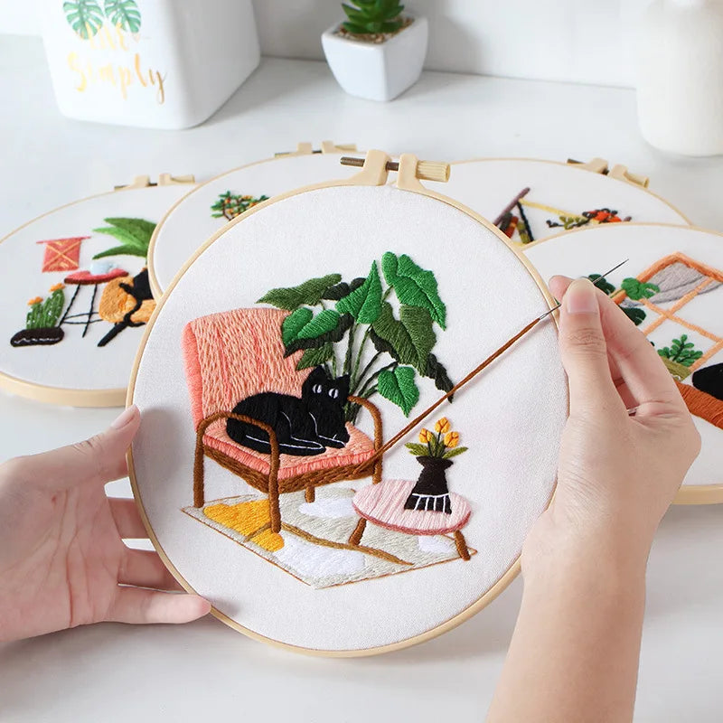 Hands embroidering a CraftHoop Cat Lover’s Home design with a cat and plant.