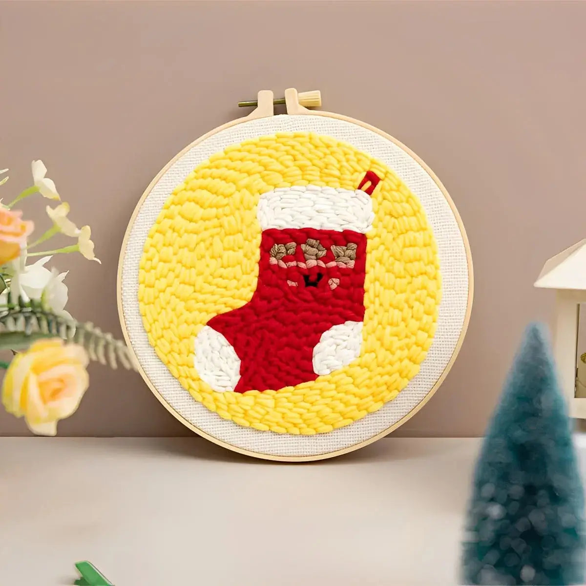 CraftHoop Christmas Cheer Punch Needle Kit featuring a festive red stocking design against a yellow background.